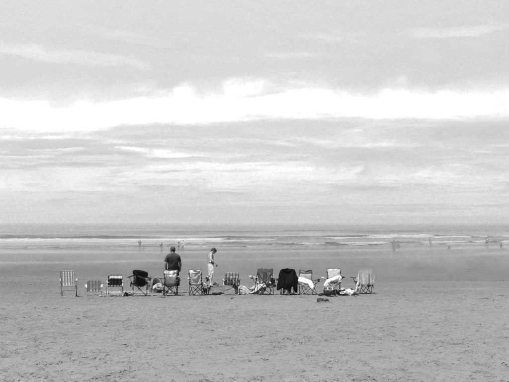 A group of people at the beach in black and white